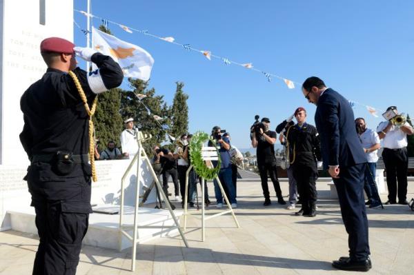 Cypriot President Nikos Christodoulides (R) bows in front of a mo<em></em>nument erected in memory of soldiers killed in the 1974 Turkish invasion of Cyprus at the Tymvos Makedo<em></em>nitissas military cemetery in Nicosia on July 20, 2024. Sirens pierced the pre-dawn quiet in Cyprus on July 20 to mark 50 years since Turkish troops landed on the Mediterranean island in an invasion that has left it divided to this day. (Photo by Iakovos HATZISTAVROU / AFP)